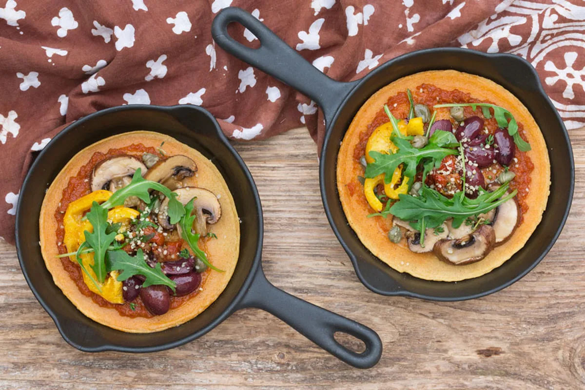 Cizrnová socca pizza s pestem, olivami a rukolou